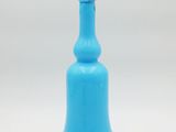 une bouteille en verre bleue munie d'une anse, sur fond blanc