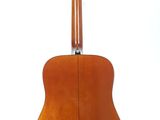 the back of an acoustic guitar on a stand against a white background