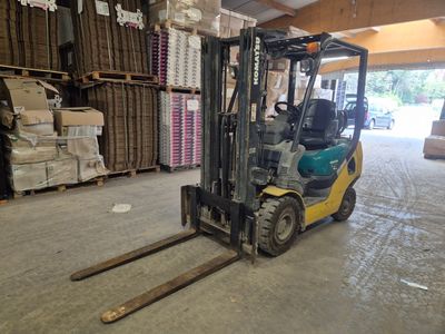 un chariot élévateur dans un entrepôt rempli de cartons