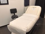 un lit blanc dans une chambre où se trouve une chaise noire