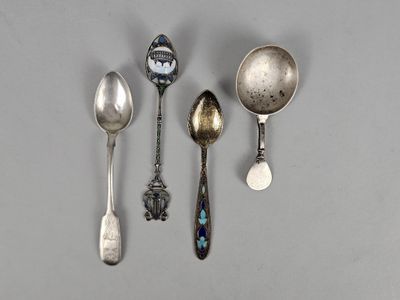 three silver spoons and a spoon with a clock on them