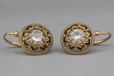 une paire de boucles d'oreilles en or ornées d'une pierre transparente au centre