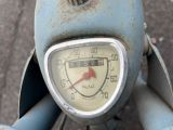 a close up of a clock on the handlebar of a scooter