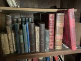 many old books on a wooden shelf in a room