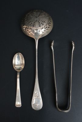 une cuillère, une cuillère et un repose-cuillère posés sur une surface noire