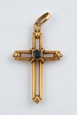 an image of a gold cross with a black stone on it