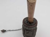 a small wooden bell with a chain attached to it