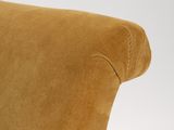 the back of a brown chair with a black and white cat sitting on top of it