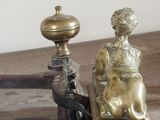 a statue of a woman sitting on a chair on a wooden table
