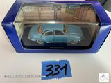 La petite voiture bleue se trouve dans la boîte posée sur la table.