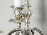 a silver candelier with three candles on it
