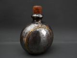 a small bottle with a wooden top on a table