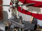 a model of a military ship with a plane on top of it