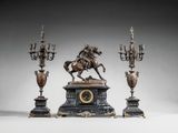 trois figurines en bronze représentant un homme à cheval et trois chandeliers