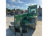 an image of a green tractor parked in a parking lot