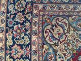 a close up of a blue and red rug with a floral design on it