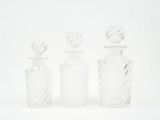 trois bouteilles en verre transparent posées les unes à côté des autres sur une surface blanche