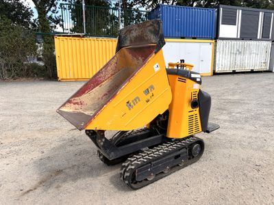 une petite machine jaune qui est posée dans la terre