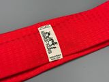 La ceinture rouge porte une petite étiquette blanche.