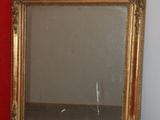 a mirror that is sitting on the floor next to a red wall