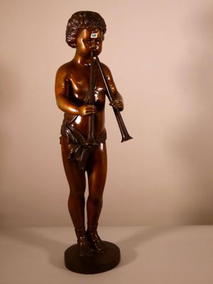statue en bronze d'un garçon tenant une flûte, posée sur un socle