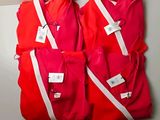 three red shirts with white stripes hang on a wall