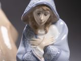 a figurine of a woman sitting next to a vase