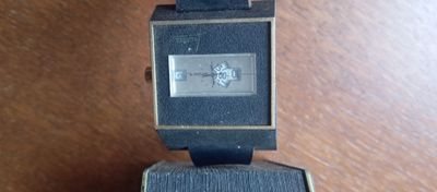 une montre posée sur une boîte, elle-même posée sur une table