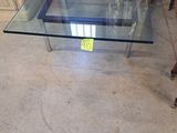 une table en verre sur laquelle est posé un panneau, au milieu d'une pièce