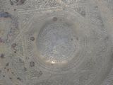 a silver plate with designs on it in the middle of a room