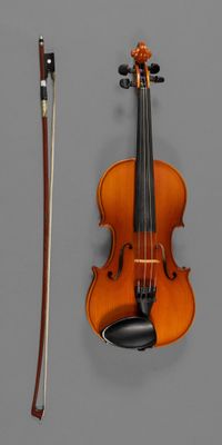 a violin and a bow on a gray surface