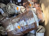 de nombreuses pelotes de laine dans une boîte contenant de la laine marron et blanche