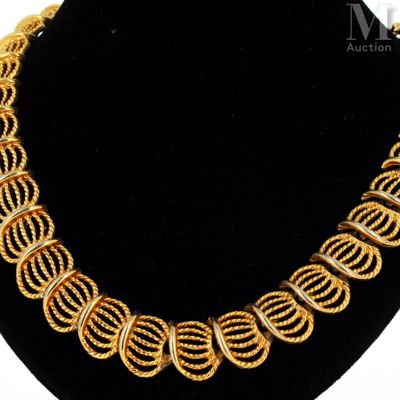 a gold necklace on a black mannequin with a gold chain