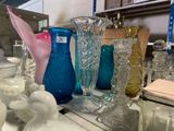many different colored glass vases on the table