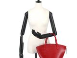 the mannequin is holding a red purse on a white mannequin