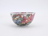 a small bowl with flowers on it on a white surface