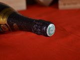 a bottle of wine sitting on a red cloth