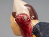 a close up of a figurine of a bird with a red beak
