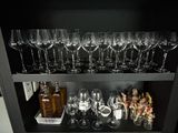 a black shelf with wine glasses and bottles on it