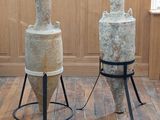 two large vases sitting on a stand in a room