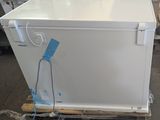 a white refrigerator sitting on a pallet in a warehouse