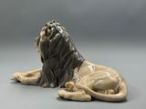 a statue of a lion laying down on the ground