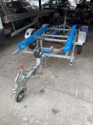 une remorque avec un bateau attelé, dans un garage
