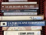 de nombreux livres dans un panier rouge posé sur l'étagère