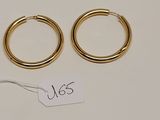 une paire de boucles d'oreilles en or sur fond blanc