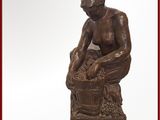 une statue représentant un garçon en train de se laver les mains dans un seau