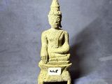 statue représentant une personne assise sur un tabouret sur lequel est posé un badge nominatif