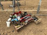 un tas d'outils posé sur une palette en bois, dans la poussière