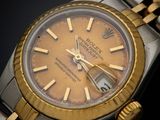 an image of a gold and silver wrist watch on a black surface