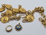 a close up of a gold chain with rings and other jewelry